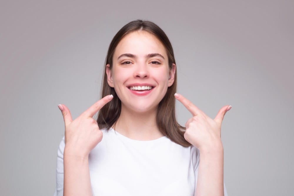 Confident woman showcasing her bright, flawless smile, highlighting the transformative results of veneers for a natural and radiant appearance.
