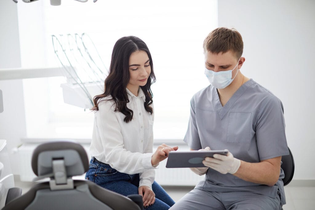 Dentist reviewing treatment information with a patient during a consultation